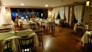 een restaurant met tafels en stoelen met witte tafellakens bij Hosteria Actinia in Villa Gesell