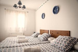 two beds in a bedroom with clocks on the wall at Casa La Alegría de La Alcarria I in Torremocha del Campo