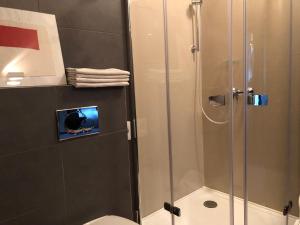 a bathroom with a glass shower with a toilet at Penzion Luxor in Trnava
