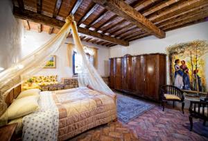 a bedroom with a bed with a mosquito net at Agriturismo Palazzo Conti A in Pienza