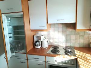 a kitchen with a stove and an open refrigerator at Ferienwohnungen am See in Obertrum am See