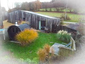 une petite maison en bois avec une cour ornée de plantes dans l'établissement Maison d'Hôtes Cerf'titude, à Érezée