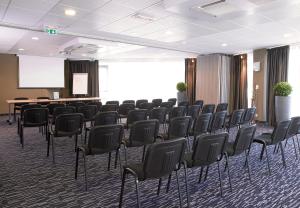 a conference room with chairs and a podium in the background at Park Hôtel & Appartements in Cholet