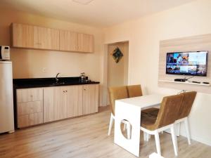 a kitchen and dining room with a white table and chairs at Flats Ouro Gramado Localizado a 900 metros da entrada do Centro de Gramado in Gramado