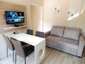 una pequeña sala de estar con sofá y mesa. en Flats Ouro Gramado Localizado a 900 metros da entrada do Centro de Gramado, en Gramado