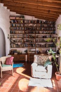 a living room with two chairs and a book shelf at Casas Perla & Maribel in Valle Gran Rey