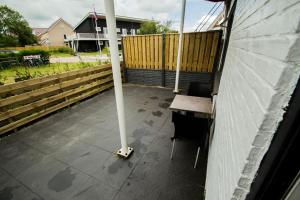 un poteau sur une terrasse avec une table et une clôture dans l'établissement De Berkenhof, à Nes