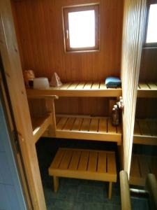 a small cabin with wooden shelves and a window at Cozy two room apartment with sauna in Hyvinkää