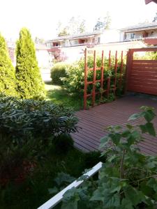 a wooden deck with a gate in a yard at Cozy two room apartment with sauna in Hyvinkää
