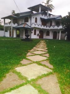 a house with a stone pathway in front of it at Pasidu Villa in Kalutara