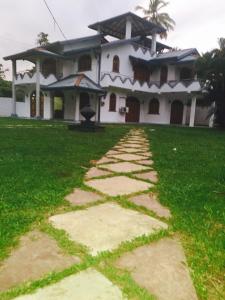 uma casa com um caminho de pedra à sua frente em Pasidu Villa em Kalutara