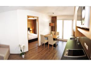 a hotel room with a table and a bedroom at Apparthotel Central in Campo Tures