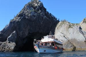 a boat in the water near a rock formation at Suítes Xodo Tour in Arraial do Cabo