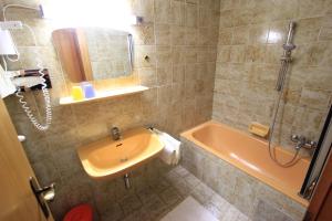 a bathroom with a tub and a sink and a shower at Ferienwohnungen Fiala-Köfer in Pörtschach am Wörthersee