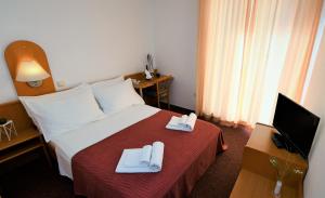 Ένα ή περισσότερα κρεβάτια σε δωμάτιο στο Hotel Alkar