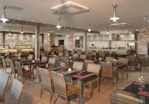 a dining room with tables and chairs and a bar at HL Rio Playa Blanca in Playa Blanca