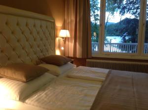 a bedroom with two beds with a large window at Residenz am See in Sankt Kanzian