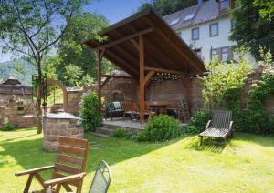 een tuinhuisje met een tafel en stoelen in de tuin bij Gästehaus Martin in Gamburg