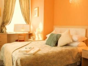 Un dormitorio con una cama con paredes naranjas y una ventana. en The Punchbowl Inn, en Thorne