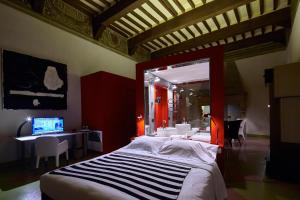 a bedroom with a bed and a desk with a computer at Palazzetto Rosso - Art Hotel in Siena