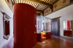 un jarrón rojo en una habitación con baño en Palazzetto Rosso - Art Hotel, en Siena