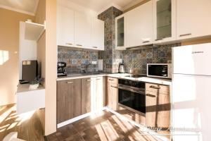 a kitchen with white cabinets and a stove top oven at Apartment Cathedral Deluxe in Varna City