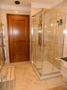 a glass shower in a bathroom with a wooden door at B&B SAN PIO in Pellezzano