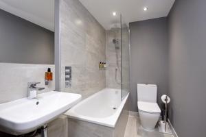 a bathroom with a sink and a tub and a toilet at Destiny Scotland New Town Apartments in Edinburgh