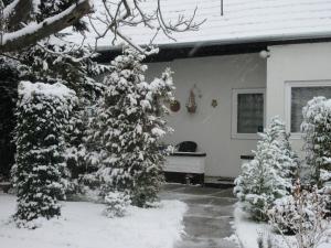 a house with snow covered trees in front of it at Sissi Residence with free parking lot in Budapest