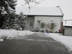 a house covered in snow with a driveway at Sissi Residence with free parking lot in Budapest