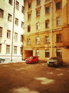 two cars parked in a parking lot in front of a building at Tihiy dvorik in Saint Petersburg