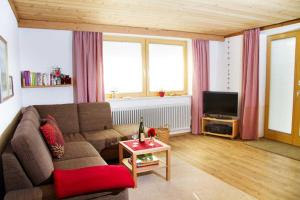 a living room with a couch and a tv at Ferienwohnung Jörg in Bad Hindelang