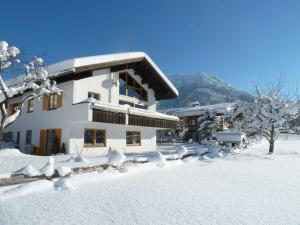 a building covered in snow with snow covered trees at Ferienwohnung Jörg in Bad Hindelang