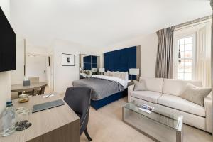a hotel room with a bed and a living room at Dunalastair Hotel Suites in Kinloch Rannoch