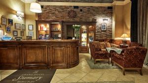 a lobby with a bar with two chairs and a table at Grand Hotel Stamary in Zakopane