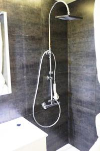 a shower with a shower head in a bathroom at Cala Balmins Sea View in Sitges