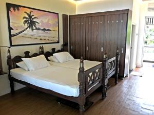 a bedroom with a large bed with a painting on the wall at Sri Gemunu Beach Resort in Unawatuna