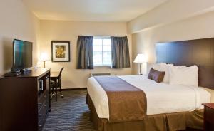 a hotel room with a bed and a flat screen tv at Cobblestone Inn & Suites - Boone in Boone