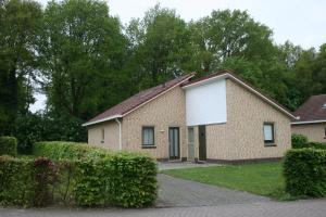 a brick house with a white garage at Lindenbergh Ommen in Ommen