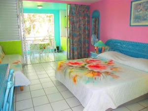 ein Schlafzimmer mit einem Bett mit Blumen darauf in der Unterkunft Studio Yucca, Pointe de la verdure, Didier BERVILLE in Le Gosier