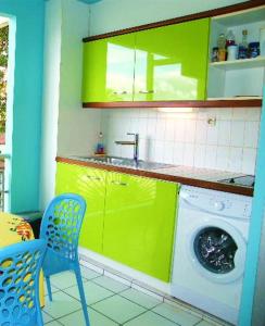 eine Küche mit grünen Schränken und einer Waschmaschine in der Unterkunft Studio Yucca, Pointe de la verdure, Didier BERVILLE in Le Gosier