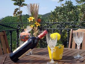 una botella de vino sentada en una mesa con dos copas en El Algarrobo by CasaTuristica en Algatocín