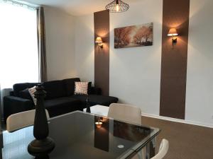 a living room with a couch and a glass table at Résidence Vendôme in Vichy