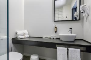 um banheiro com uma pia e um espelho em Sport Hotel Gym + SPA na Covilh