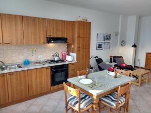 eine Küche mit Holzschränken und einem Tisch mit Stühlen in der Unterkunft Bright Apartment in Marostica in Marostica