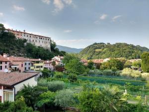 a town with a river and buildings and trees at Bright Apartment in Marostica in Marostica
