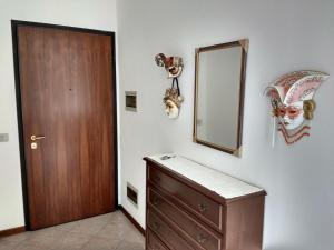ein Badezimmer mit einer Holztür, einer Kommode und einem Spiegel in der Unterkunft Bright Apartment in Marostica in Marostica