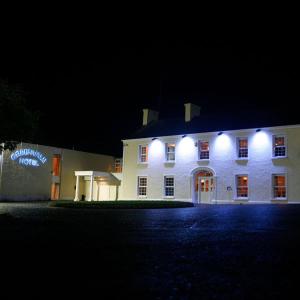 a white building with lights on it at night at Greenvale Hotel in Cookstown