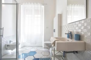 a white bathroom with a sink and a toilet at Ciutat Alghero in Alghero