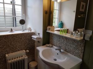 La salle de bains est pourvue d'un lavabo et d'un miroir. dans l'établissement Résidence CoatArmor, à Tonquédec